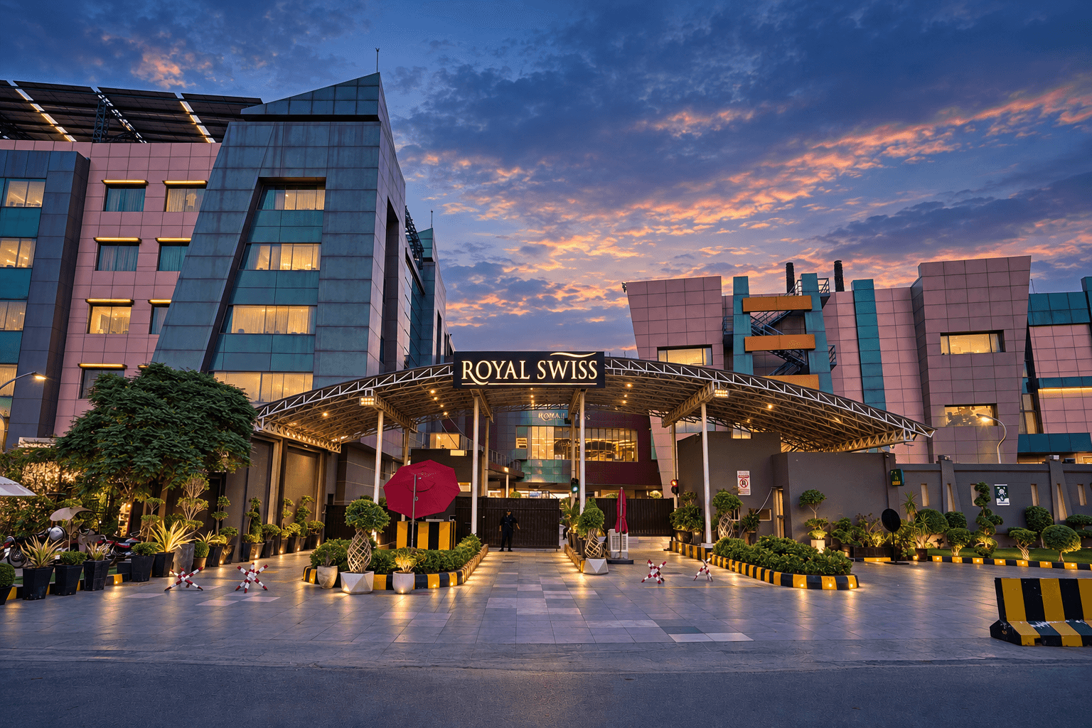 Royal Swiss Lahore at dusk, seen across the forecourt